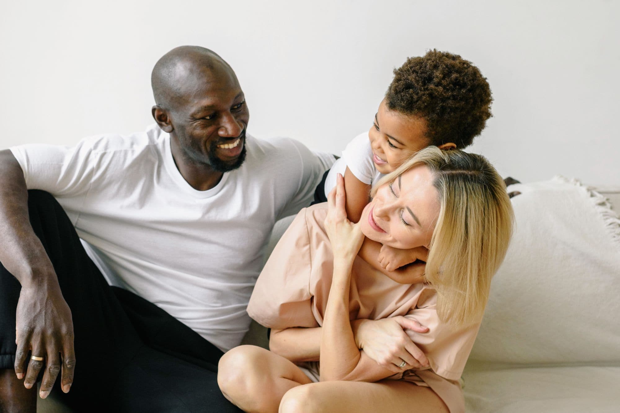 A family laughing together on a couch at home