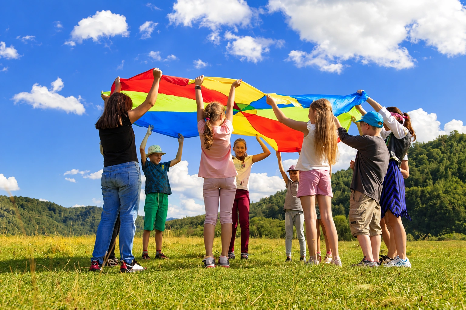 Children playing together outdoors under a colorful parachute